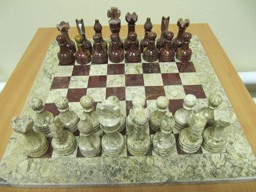 Шахматная доска сделана из тех же двух видов натурального камня, что и фигуры